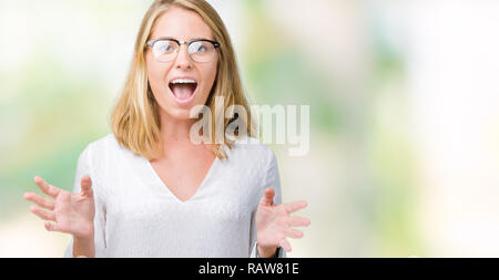 Giovane e bella donna che indossa gli occhiali su sfondo isolato paura e scioccato con sorpresa di espressione, paura ed entusiasti di faccia. Foto Stock