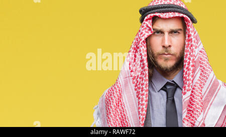 Giovane bello arabian uomo con capelli lunghi che indossa keffiyeh su sfondo isolato scettico e nervoso, accigliata sconvolto a causa del problema. P negativa Foto Stock