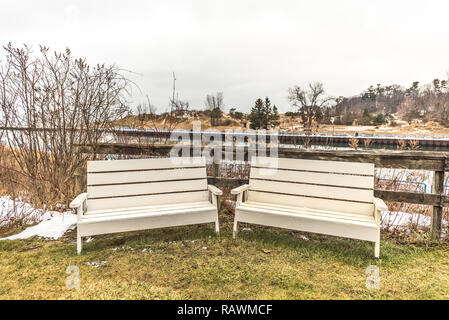 Due color crema panche in attesa che qualcuno sedersi e visita con il Fiume Bianco dietro di loro. Foto Stock