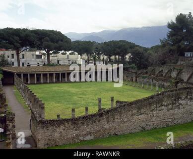 L'Italia. Pompei. Quadriportico dei teatri o caserma di gladiatori. Esso copre una grande quadrilatero circondato da 74 dorico colonne di tufo utilizzato come un foyer. In questa zona gli spettatori potrebbe arrestarsi durante gli intervalli degli spettacoli teatrali. Dopo il terremoto del 62 D.C. La costruzione ha cambiato la sua funzione e divenne come caserma di gladiatori. Area del teatro. Campania. Foto Stock