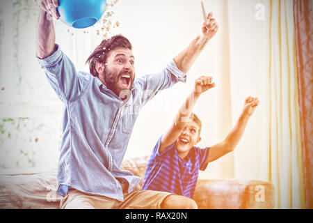 Entusiasta il padre e il figlio di guardare la televisione Foto Stock