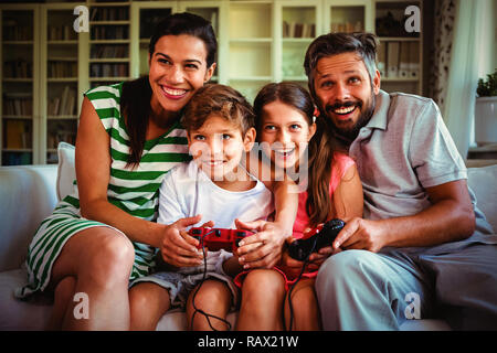 I genitori di giocare con i videogiochi con i bambini Foto Stock