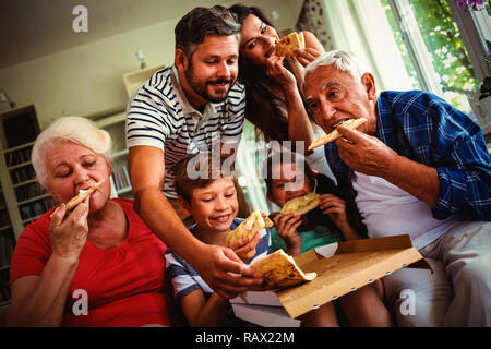 Multi-generazione famiglia mangiare la pizza insieme Foto Stock