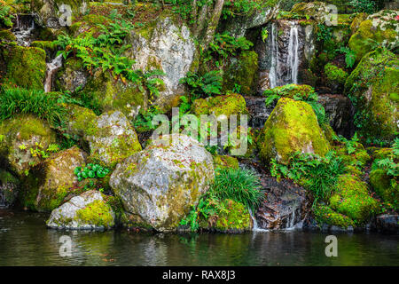 Vista della cascata, pietre e laghetto in giardino, Giappone Foto Stock