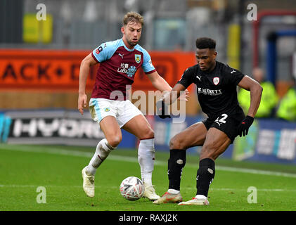 Burnley's Charlie Taylor (sinistra) e Barnsley's Dimitri Cavare (destra) battaglia per la sfera durante la Emirates FA Cup, terzo round corrispondono a Turf Moor, Burnley. Foto Stock