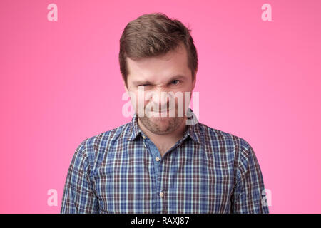 Ritratto di un uomo arrabbiato sulla backfround rosa. Negativo emozione per il viso Foto Stock