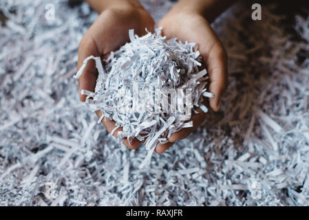 La mano che mostra il mucchio della carta tagliuzzata. Concetto di riciclaggio e del lavoro di ufficio di informazioni riservate Foto Stock