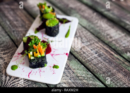 Materie vegano rotoli di sushi con verdure e salsa verde con lo styling di cibo nel ristorante Foto Stock