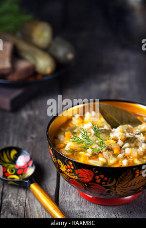 Il russo pickle vegan zuppa nel recipiente tradizionale con dipinti khohloma servita in stile rustico Foto Stock