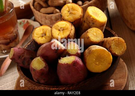 Pisang Rebus e Ubi Rebus. Banana cotta a vapore piantaggine e patate dolci, snack popolare che servita con Sundanese bevande alle erbe di Bandrek Bajigur e. Foto Stock