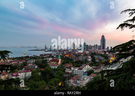 La baia di Qingdao e la chiesa luterana visto dalla collina del parco di segnale a sera, Qingdao, Cina Foto Stock