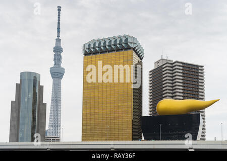 TOKYO, Giappone - 19 Novembre 2018: La Asahi fiamma e birra con torre di Tokyo Skytree vicino al fiume Sumida a Tokyo in Giappone. Foto Stock