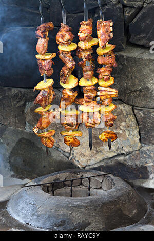 Agnello e spiedini di pollo con patate sullo spillone, al di fuori del forno tandoori. Foto Stock