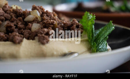 Piastra del tipico hummus libanese condito in vari modi Foto Stock