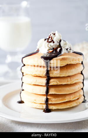 Grappolo di Pancake fatti in casa serviti con latte per la prima colazione Foto Stock