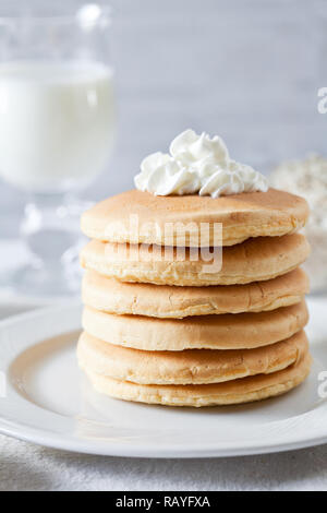 Grappolo di Pancake fatti in casa serviti con latte per la prima colazione Foto Stock