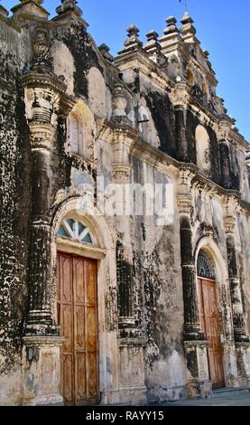 Una vecchia chiesa spiovente con porte in legno sotto un cielo blu Foto Stock