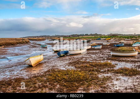 Barche a bassa marea ormeggiata in un torrente attraverso le saline a Morston sulla Costa North Norfolk. Foto Stock