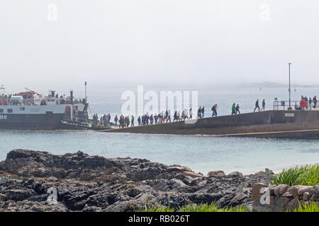 Caledonian MacBrayne traghetto. Primo-piedi dei passeggeri della giornata, arrivando da Fionnphort, Mull, banchina di sbarco San Ronan's Bay, Isola di Iona. Le Ebridi Interne. Costa ovest della Scozia. Il Regno Unito.​ Foto Stock
