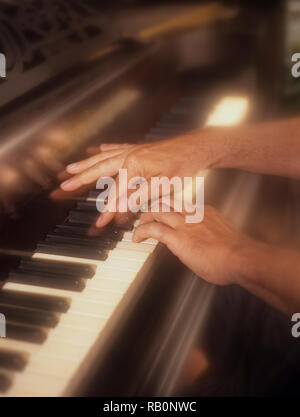 Uomo giocando attivamente il pianoforte con un morbido effetto di filtro per enfatizzare la pressione dei tasti di pianoforte in tempo reale Foto Stock
