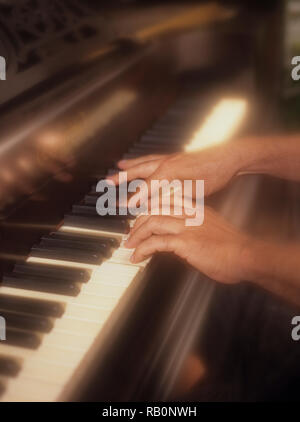 Uomo giocando attivamente il pianoforte con un morbido effetto di filtro per enfatizzare la pressione dei tasti di pianoforte in tempo reale Foto Stock