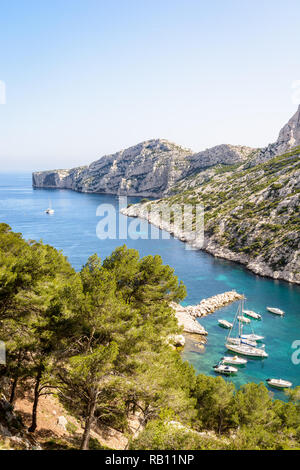 Vista la calanque de Morgiou sulla costa mediterranea nei pressi di Marsiglia, Francia, con barche di ormeggio in acque turchesi su una soleggiata giornata di primavera. Foto Stock