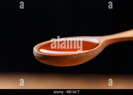 Un cucchiaio di legno riempita con miele di fresco. Close-up. Macro. Foto Stock