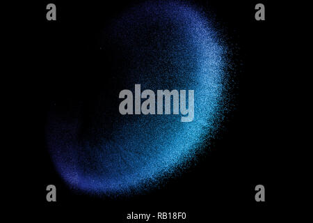 Blu di sabbia colorata esplosione isolata su sfondo blu. Abstract blue sand cloud. Blu di sabbia colorata schizzare contro su sfondo scuro. Sandy fly wa Foto Stock