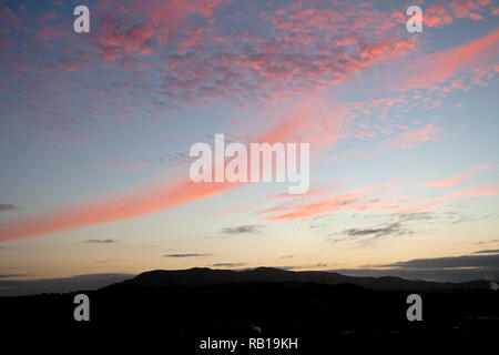 Al tramonto sul vertice di Arthur' Seat un colore rosa nuvole al tramonto guardando verso il Pentland Hills, Edimburgo, Scozia, Regno Unito, Europa Foto Stock