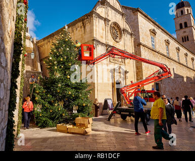 Dubrovnik, Croazia, città dipendenti che lavorano presso la decorazione di un albero di Natale in città vecchia parte della città sotto il suo sguardo vigile di passerby Foto Stock