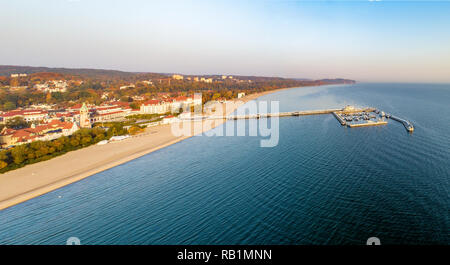 Antenna di ampio panorama di Sopot resort vicino Gdank in Polonia nella luce di sunrise. Molo in legno (molo) con marina, yacht, spiaggia, vecchio faro, vacanze in Foto Stock