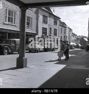 Degli anni Cinquanta, vista esterna della high street nel mercato Inglese città di Totnes, Devon, Inghilterra sudoccidentale, Regno Unito come è stato in questo momento, con molti negozi indipendenti compresi; L. Manning, G.Heath & Figlio, F. Shinner & Figlio e Briggs. Foto Stock