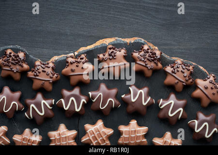 A forma di stella cioccolatini sul legno scuro sfondo, il bordo Foto Stock