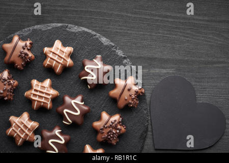A forma di stella sul cioccolato scuro dello sfondo testurizzata con cuore nero Foto Stock