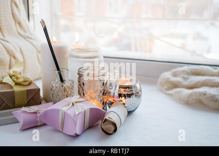 Cera di paraffina per candele e uno delle tealight in un vetro portacandele e aroma stick, romantico confezioni regalo, in piedi su un davanzale di primo mattino, concetto o Foto Stock