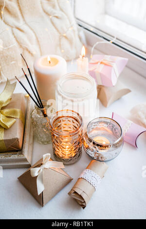 Cera di paraffina per candele e uno delle tealight in un vetro portacandele e aroma stick, romantico confezioni regalo, in piedi su un davanzale di primo mattino, concetto o Foto Stock