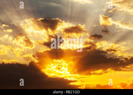 Il sole che splende attraverso basse nubi Foto Stock