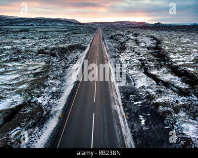 Strada in Islanda circondato da campi di lava ricoperti di neve vista aerea Foto Stock