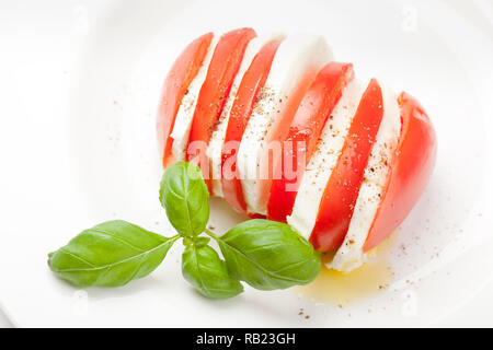 Il motorino di avviamento Italiano chiamato 'insalata caprese è un mix di pomodori a fette di mozzarella, basilico e condite con sale e pepe e olio di oliva. Foto Stock