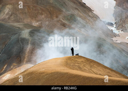 Singola persona sulla collina nel fumo del paesaggio vulcanico Foto Stock