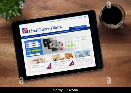 Il sito web di primo Citizens Bank è visto su un tablet iPad, su di un tavolo di legno lungo con un caffè espresso e una pianta di casa (solo uso editoriale). Foto Stock
