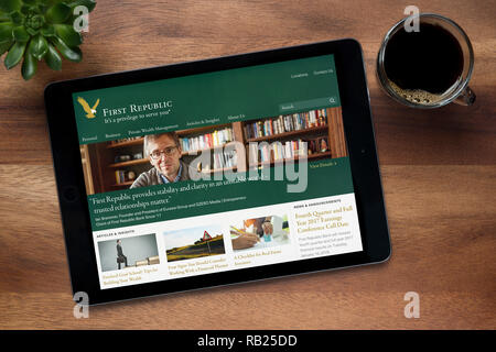 Il sito web della Prima Repubblica Banca è visto su un tablet iPad, su di un tavolo di legno lungo con un caffè espresso e una pianta di casa (solo uso editoriale). Foto Stock