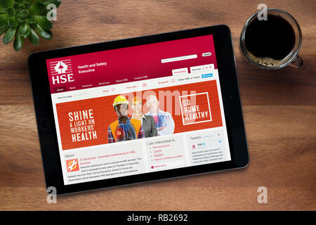 Il sito web di HSE (Comitato esecutivo per la salute e la sicurezza) è visto su un tablet iPad, su di un tavolo di legno (solo uso editoriale). Foto Stock