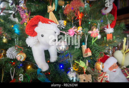 Close-up Decorazione per albero di Natale con focus su orso polare in bianco e rosso Santa hat. Foto Stock