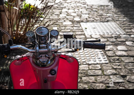 Una rosa scooter in una strada acciottolata Foto Stock