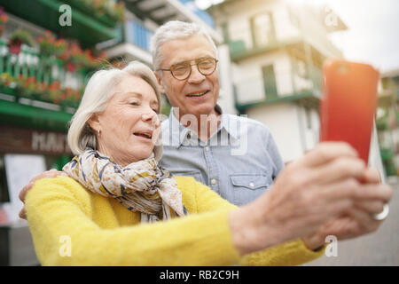 Attraente coppia senior prendendo un selfie all'aperto Foto Stock