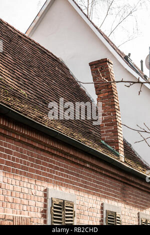 Vuoto vecchia casa di mattoni con camino storte Foto Stock