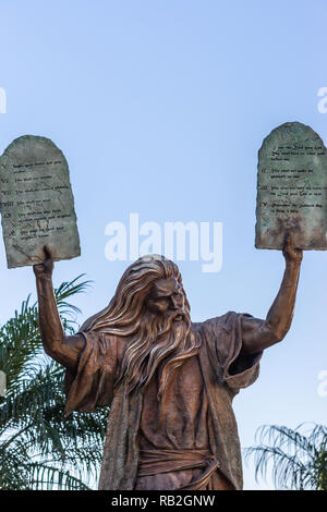 Garden Grove, California, Stati Uniti d'America - 13 dicembre 2018: cristallo Cattedrale di Cristo. Primo piano della statua di bronzo di Mosè mettendo i dieci comandamenti di due tab Foto Stock