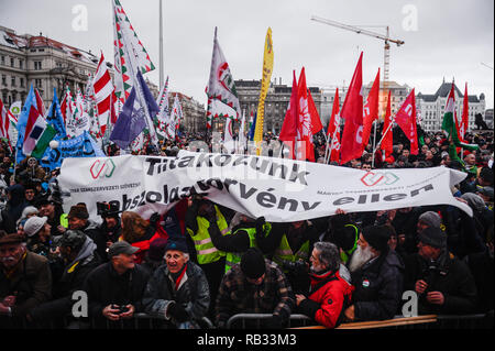 Budapest, Ungheria. Gen 5, 2019. Manifestanti hanno visto tenendo un banner con bandiere durante una manifestazione di protesta in piazza degli Eroi contro la recente approvazione di una legge sul lavoro noto come Slave legge introdotta dal Primo Ministro ungherese Viktor Orban. Dal dicembre 2018, gli ungheresi sono scesi in piazza per più di una settimana per protestare contro la nuova legge sul lavoro e l'introduzione di una nuova Corte parallela sistema. Credito: Omar Marques/SOPA Immagini/ZUMA filo/Alamy Live News Foto Stock