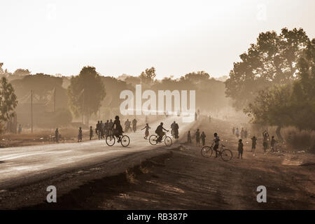 Autostrada 1 all'uscita di Ouagadougou, Burkina Faso, al tramonto con il profilarsi di persone. Paesaggi africani. Foto Stock